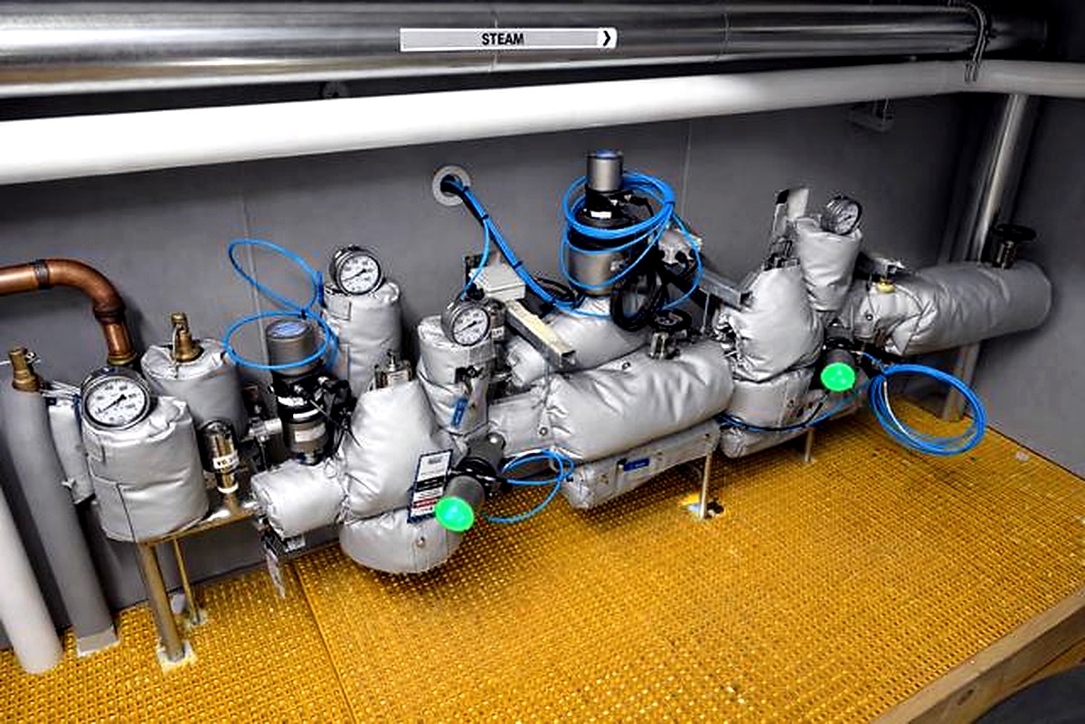 Thermal jackets on steam header valve assemblies with pressure gauges in an industrial steam system